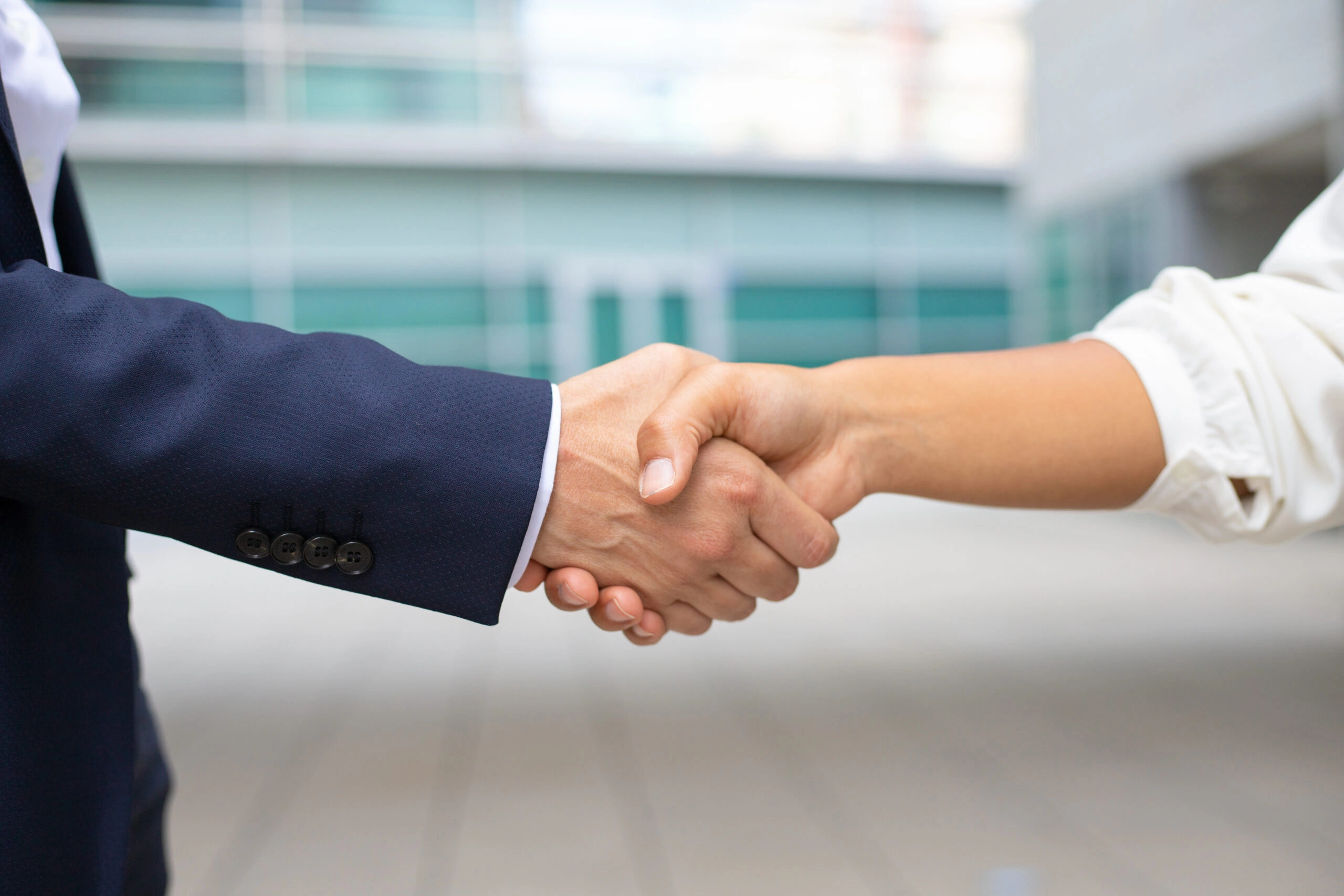 Closeup shot business handshake cropped shot two people wearing formal suits shaking hands business